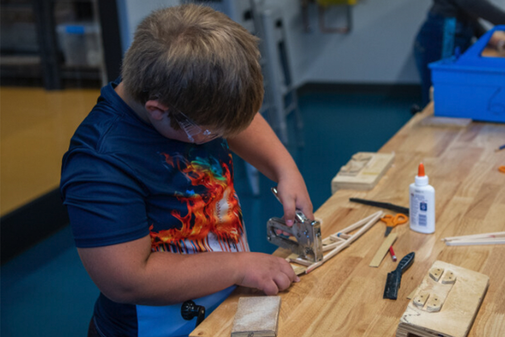 boy making wooden wing rib